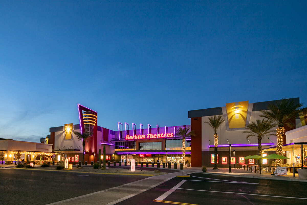Park West open-air shopping and dining promenade with palm trees at dusk