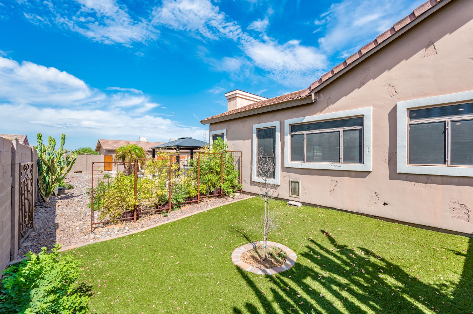 Side yard with green turf, garden trellis and decorative gate