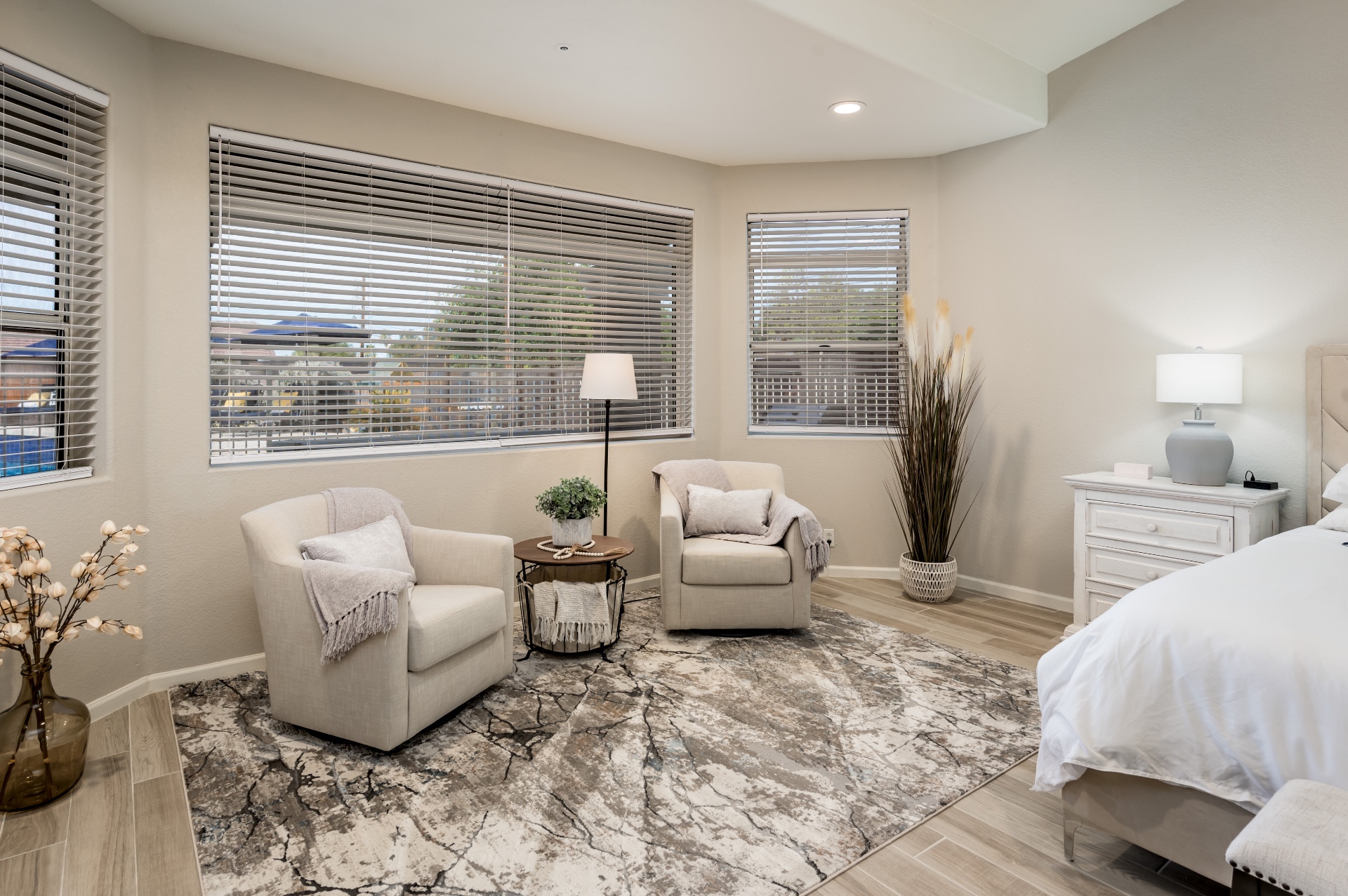Primary bedroom sitting area with two swivel chairs by the bay window