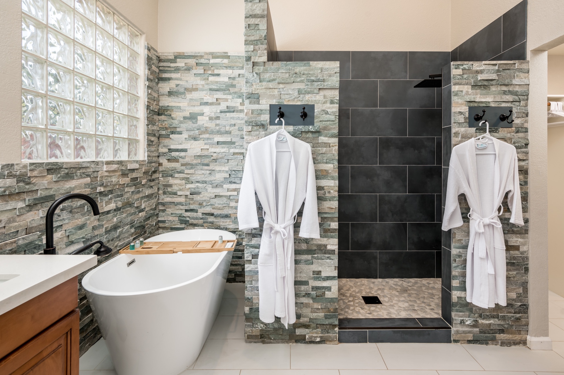Freestanding tub and walk-in slate shower with stacked stone walls