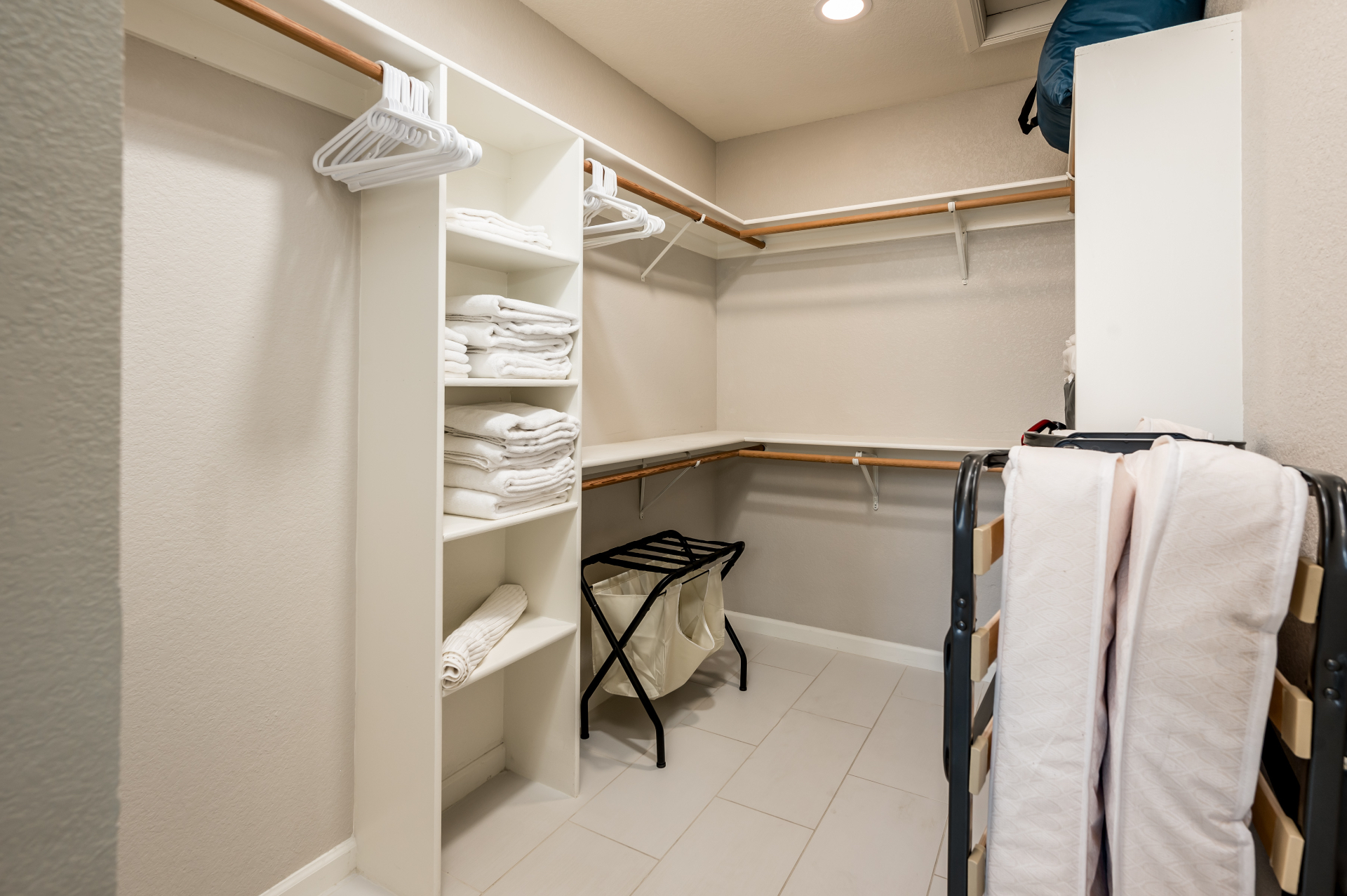 Walk-in closet with shelving, hangers and folded linens