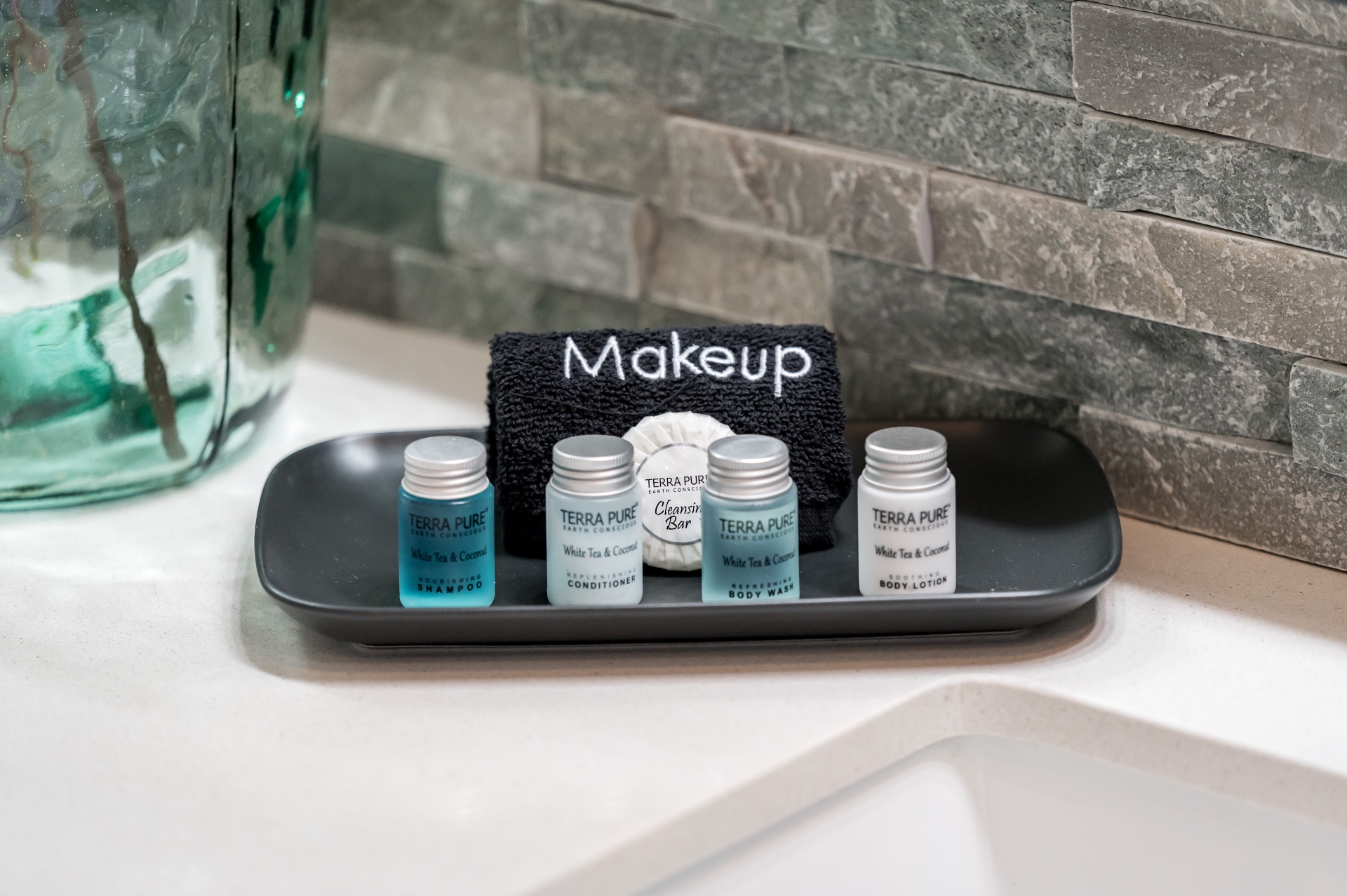 Tray of Terra Pure shampoo, conditioner, body wash and lotion with makeup cloth