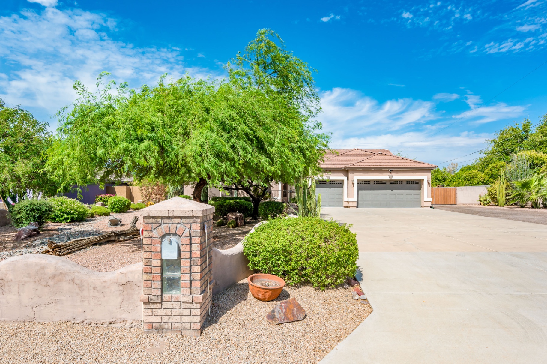 Front of home with mature mesquite tree and brick mailbox