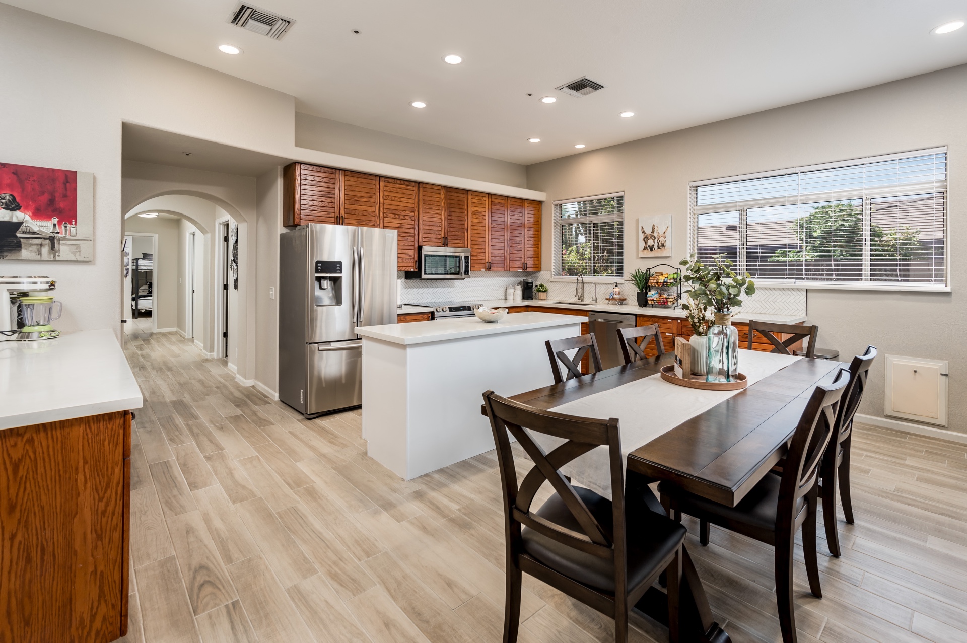 Open kitchen with stainless appliances, island and dining table