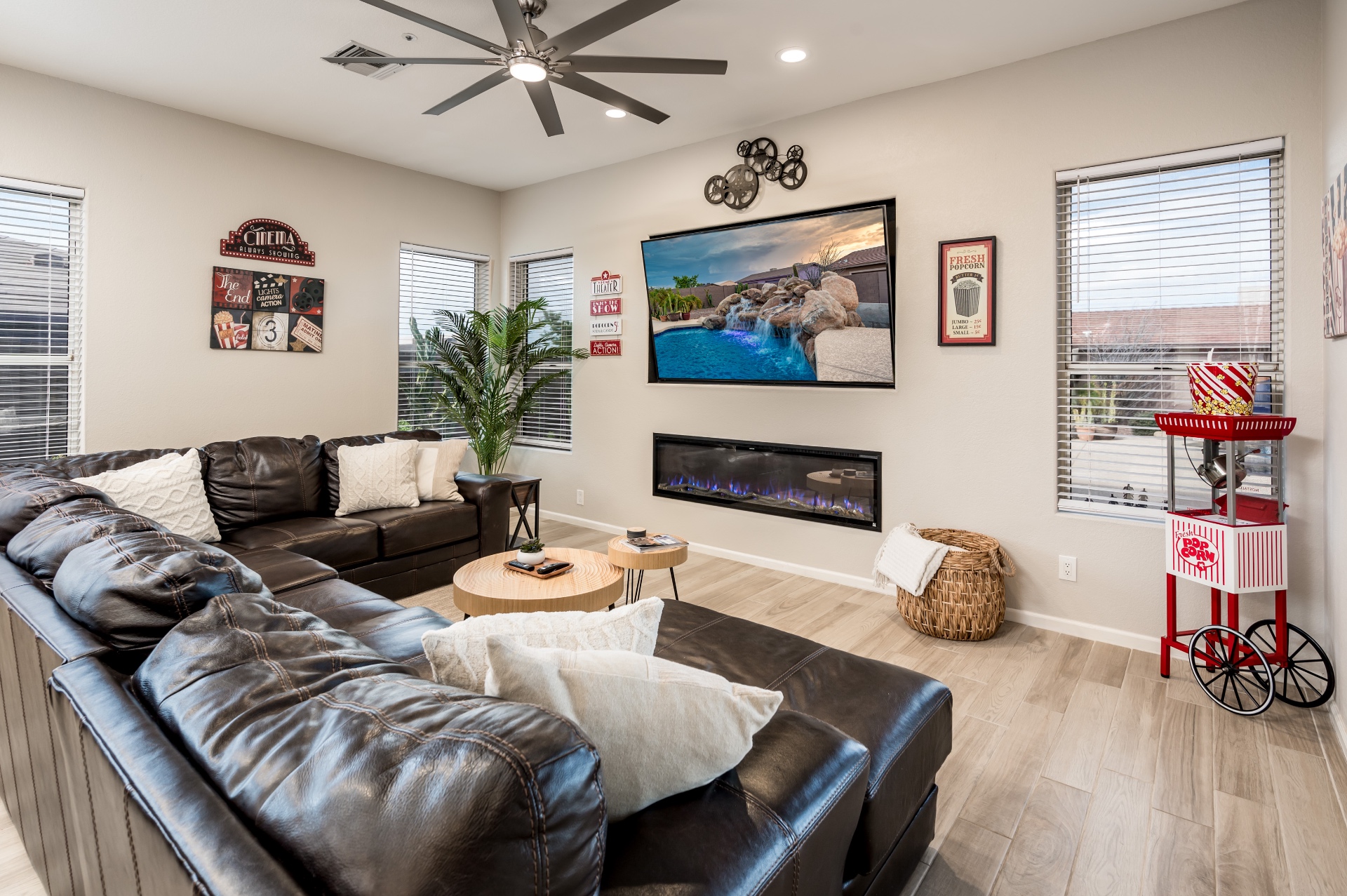 Cozy living room with leather sectional, fireplace and movie-themed decor